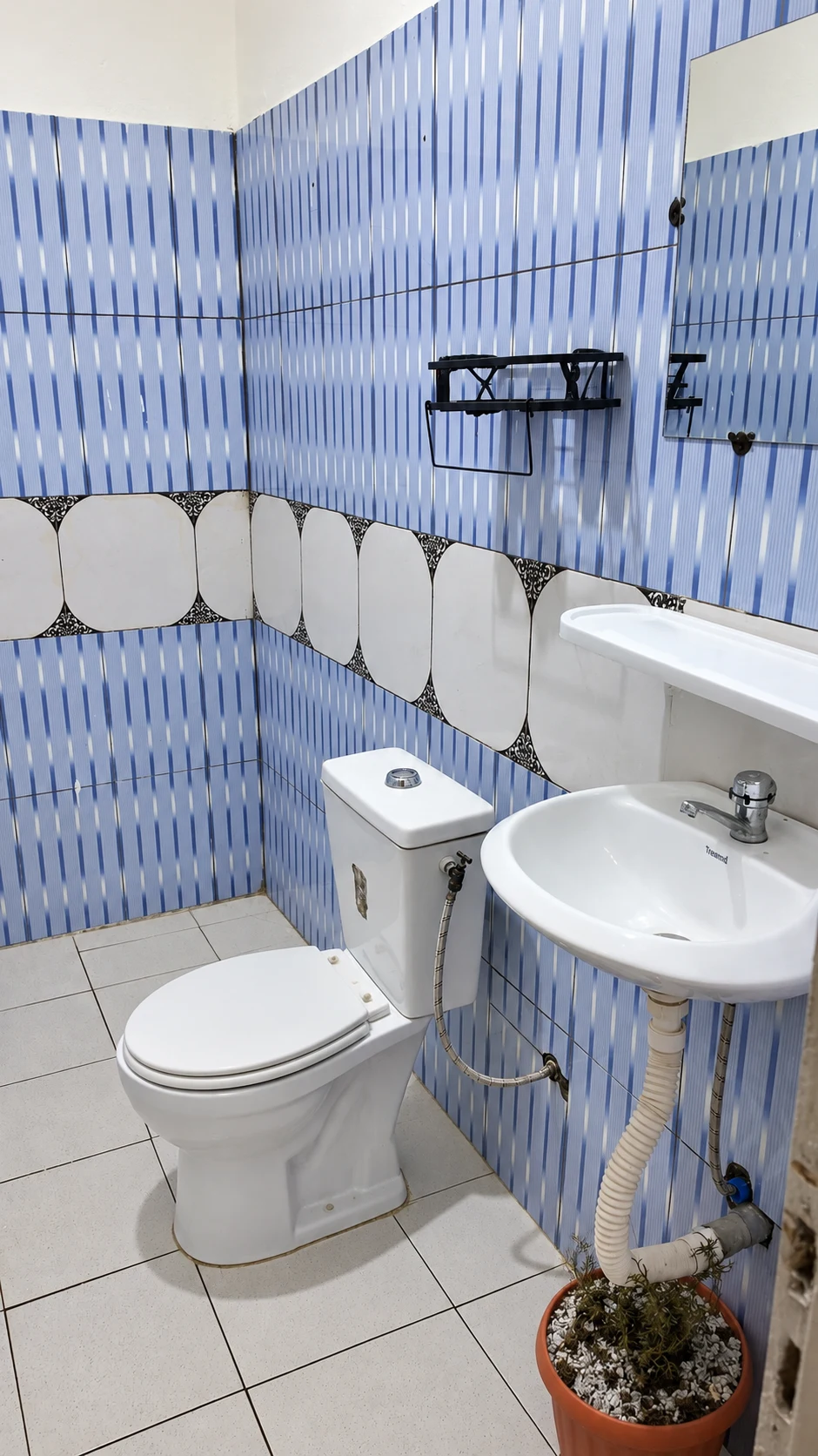 La salle d’eau du studio, avec lavabo, miroir et carrelage bleu